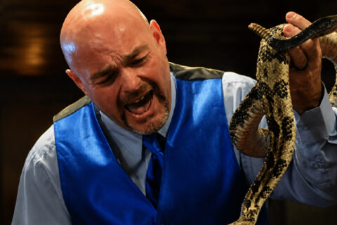 Jamie Coots handling a venomous snake during a church service